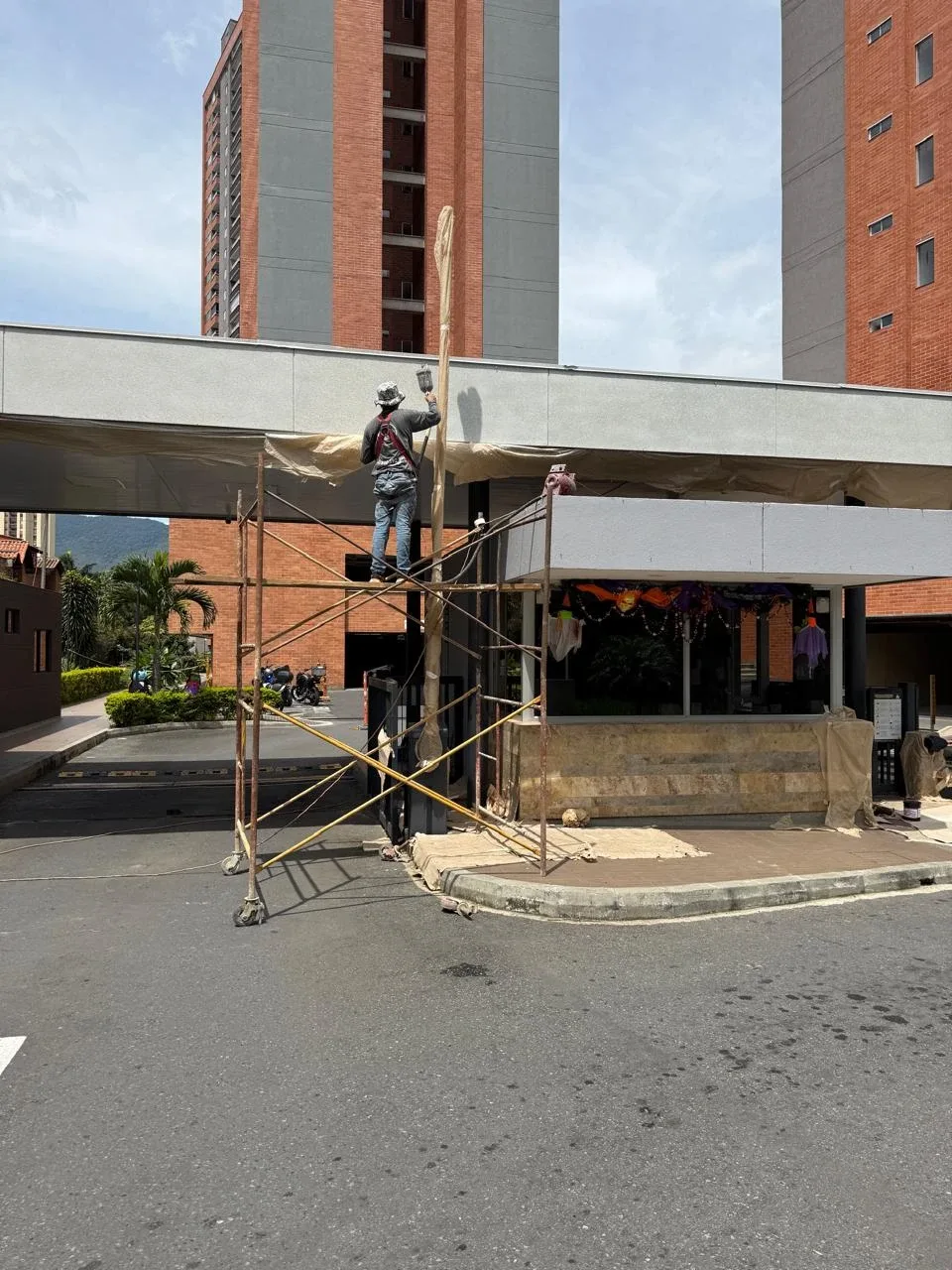 Operario pintando una fachada desde un andamio