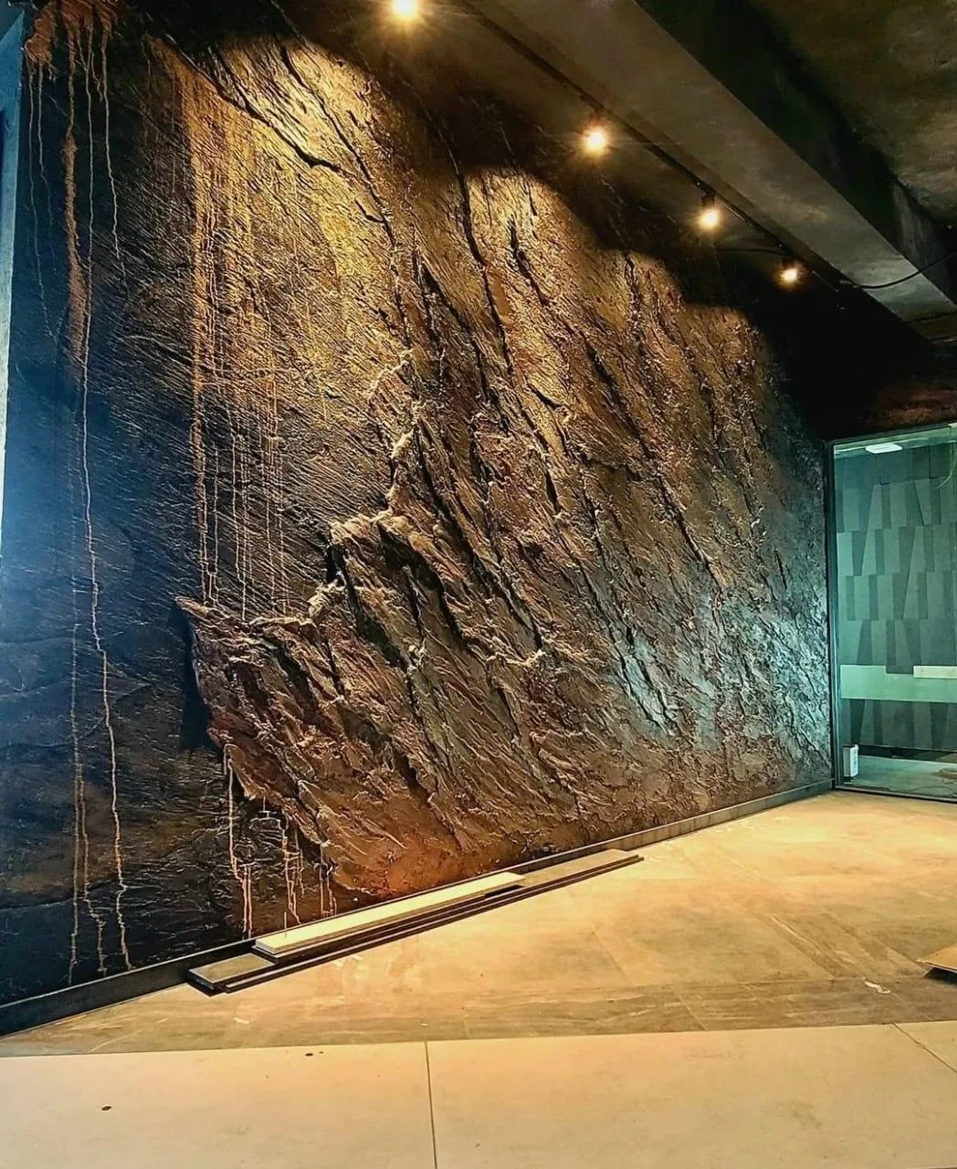 Muro con revestimiento efecto piedra e iluminación